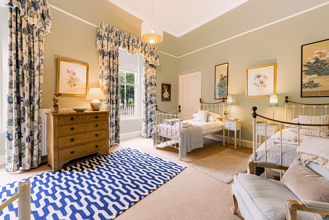 Twin bedroom with two single beds and an antique chest of drawers