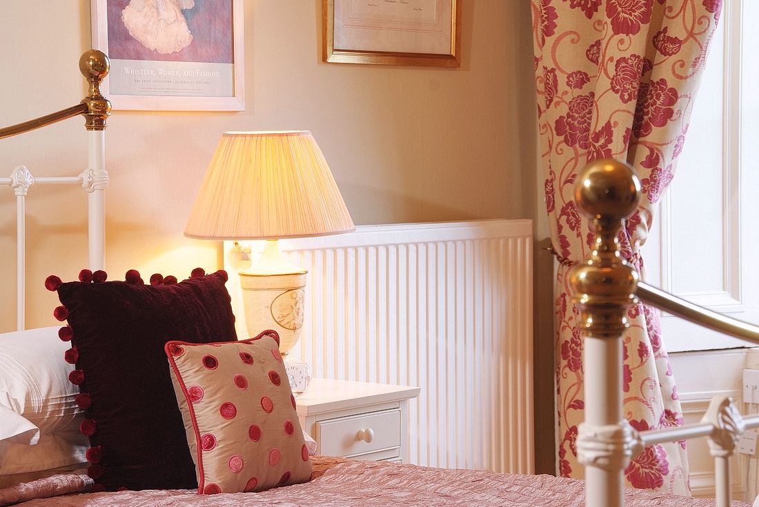 Master bedroom detail with lamp and velvet cushions